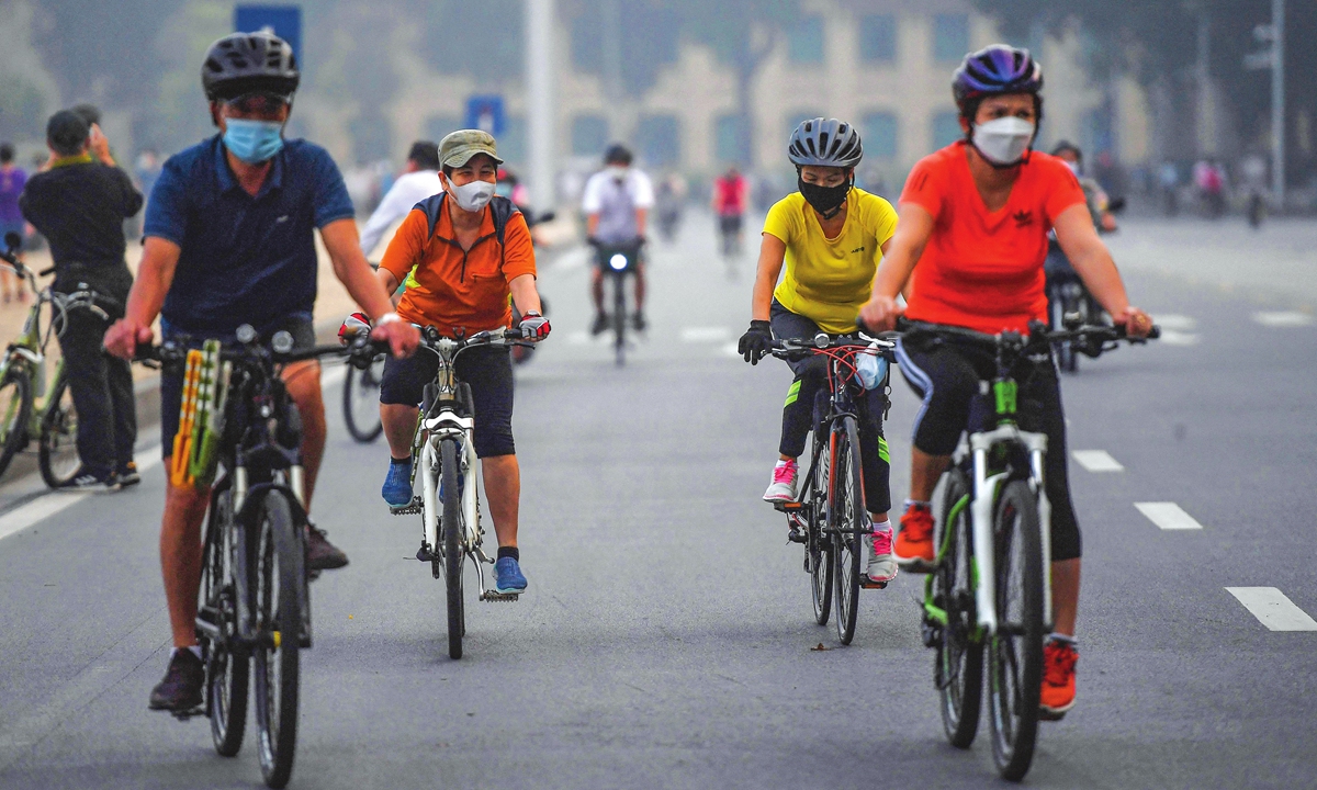 People ride bicycles along a street in Hanoi, Vietnam on Tuesday, after city authorities allowed outdoor sport activities following the easing of COVID-19 restrictions. Photo: AFP