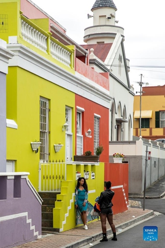 A tourist poses for photos in Bo-Kaap area of Cape Town, South Africa, Sept. 27, 2021. Bo-Kaap, one of the oldest residential areas in Cape Town with colorful houses, attracts many tourists for photography.(Photo: Xinhua)
