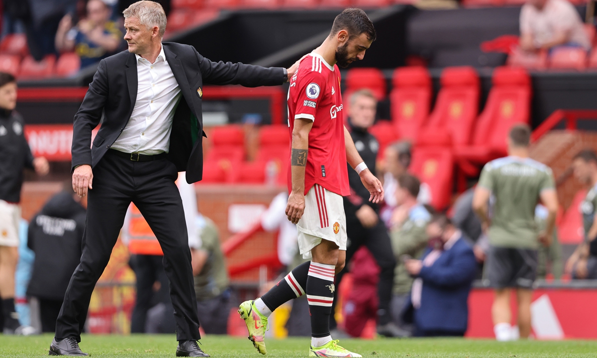Manchester United midfielder Bruno Fernandes (right) and manager Ole Gunnar Solskjaer walk off the pitch after losing to Aston Villa on Saturday in Manchester, England. Photo: VCG