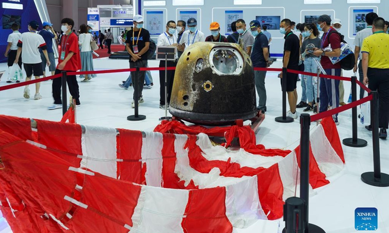 People look at the parachute and return capsule of the Chang'e-5 probe on display during the 13th China International Aviation and Aerospace Exhibition, or Airshow China 2021, in Zhuhai, south China's Guangdong Province, Sept. 29, 2021.Photo:Xinhua