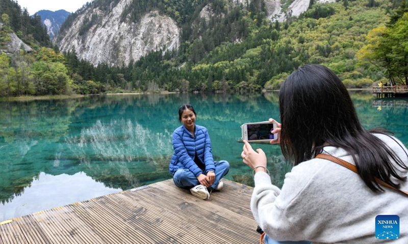 Tourists take photos at the Jiuzhaigou scenic spot in Jiuzhaigou County, southwest China's Sichuan Province, Sept. 27, 2021.Photo:Xinhua