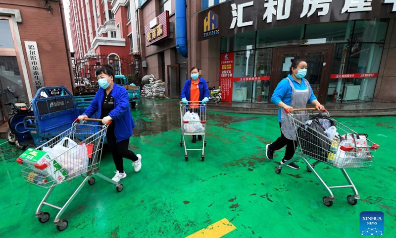 Supermarket employees deliver daily necessities to residents under close-off management in Bayan County of Harbin, northeast China's Heilongjiang Province, Sept. 27, 2021. Local authorities have prioritized delivery services to ensure the supply of necessities for residents under close-off management. The pricing of commodities remains stable in the county.Photo:Xinhua