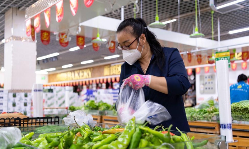 A supermarket employee selects vegetables ordered online by residents under close-off management in Bayan County of Harbin, northeast China's Heilongjiang Province, Sept. 27, 2021.Photo:Xinhua