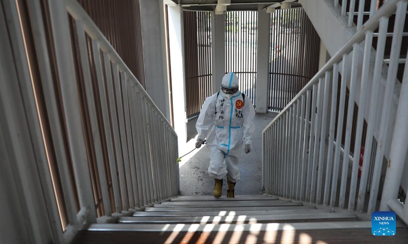 A fireman disinfects the entrance of a skywalk in Xiamen, southeast China's Fujian Province, Oct. 5, 2021. Outdoor public places in Xiamen started to reopen from Oct. 5, as the results of the sixth round of citywide nucleic acid testing all came out negative. (Photo :Xinhua) 