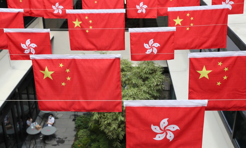 The Chinese national flags and the regional flags of the Hong Kong Special Administrative Region are seen in the Central district of Hong Kong, south China, Oct. 1, 2021. (Xinhua/Wu Xiaochu)