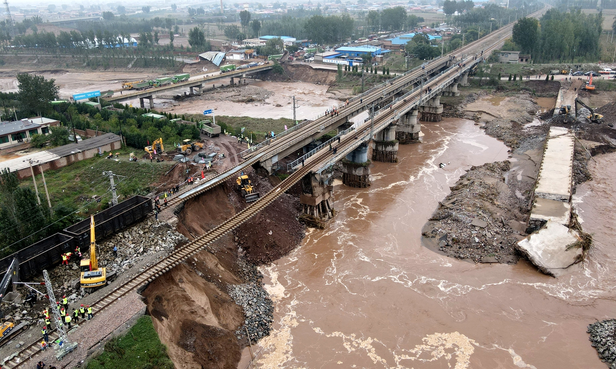Maintenance personnel make urgent repairs to a railway crossing over the Changyuan River in Qixian county, North China's Shanxi Province on Thursday. Shanxi was hit hard by heavy floods during the National Day holidays, and the abutments under the railway were destroyed. Photo: VCG