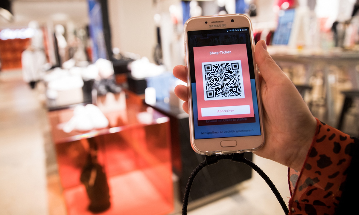 An employee is holding a mobile device with the bonprix App at a press event in the new Bonprix Pilot store in downtown Hamburg, Germany. Photo: AFP