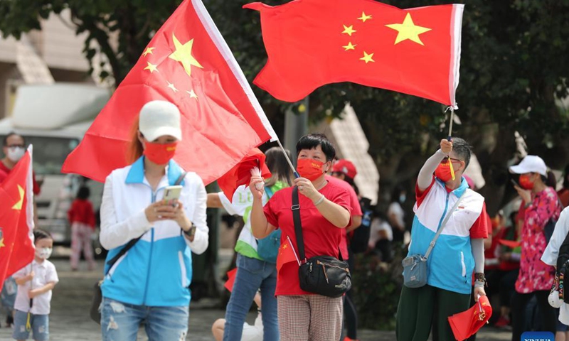 Citizens wave China's national flag in Tsim Sha Tsui, south China's Hong Kong, Oct. 1, 2021. Hong Kong on Friday saw various activities in celebration of the National Day, both official and grassroots ones, including flag-raising ceremonies and bus parades. (Xinhua)