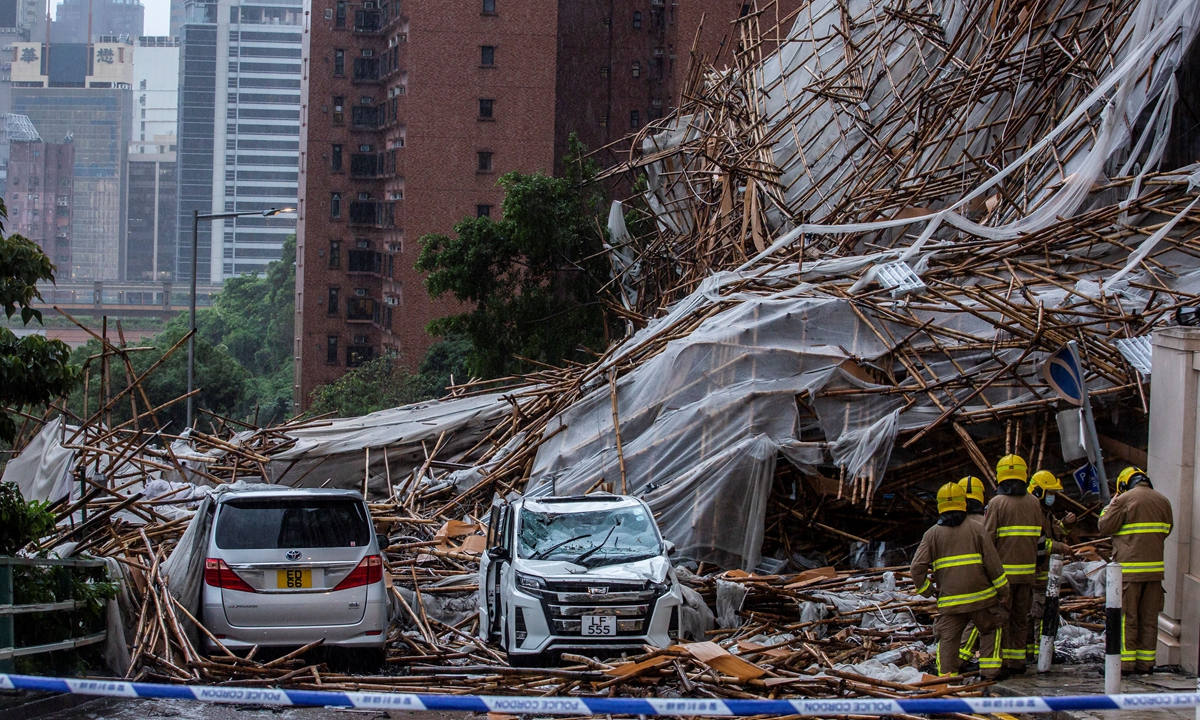 Rescuers arrive at the scene where bamboo scaffolding of a high-rise residential building collapsed on a road, following strong winds and heavy rain from a tropical storm, in Hong Kong on Friday. Photo: AFP
