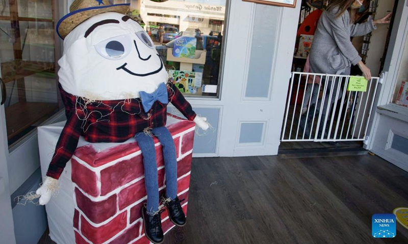 A scarecrow is displayed in front of a store at Steveston Village in Richmond, British Columbia, Canada, on Oct. 6, 2021. Scarecrows are created and placed outside stores at Steveston Village where people are encouraged to vote for the best designs of the year for Steveston Scarecrow Crawl competition. Photo:Xinhua