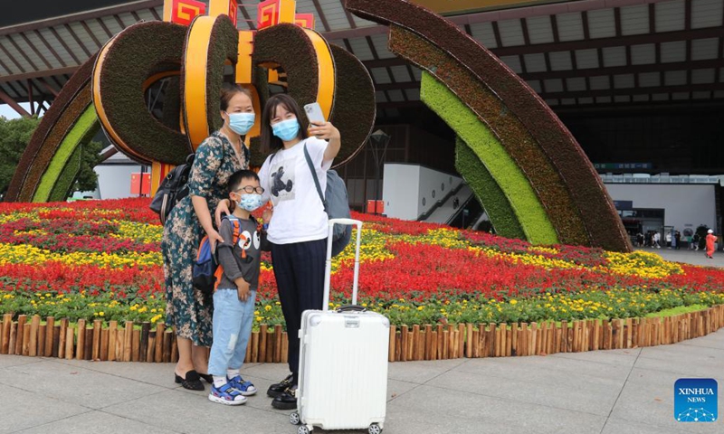 Passengers take selfies before their return trip at the Suzhou railway station in Suzhou, east China's Jiangsu Province, Oct. 7, 2021. Transportation hubs across China are witnessing the peak of return passengers as the week-long holiday draws to an end on Thursday.Photo:Xinhua