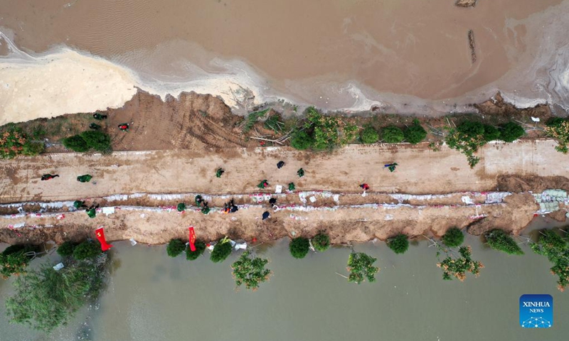 Aerial photo shows rescuers fortifying temporary dyke against the flood at Lianbo Village in Hejin City, north China's Shanxi Province, Oct. 10, 2021. (Xinhua/Zhan Yan)
