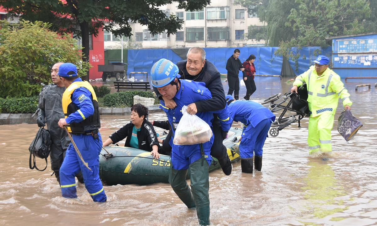 Members of China's Blue Sky Rescue Team help residents in the flood-hit Lingshi county, North China's Shanxi Province, to relocate on October 10. Photo: Courtesy of the Blue Sky Rescue Team