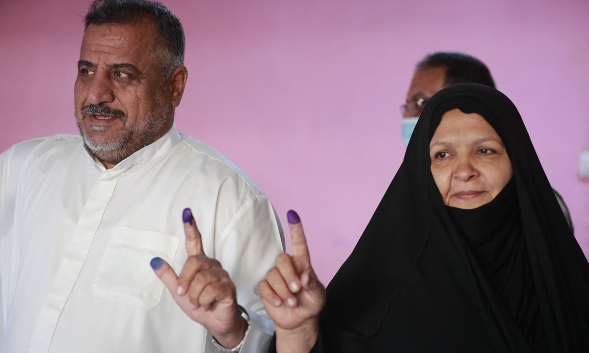 Iraqi voters show their inked fingers after casting their ballots at a polling station in Baghdad, Iraq on Sunday in the country's early parliamentary election. The electoral commission said it expects to publish preliminary results within 24 hours of the close of polls. Photo: AFP