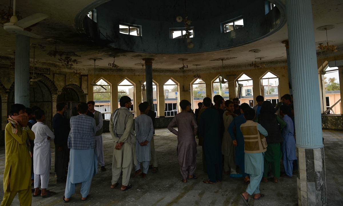 People gahter inside the damaged Sayed Abad Shiite mosque a day after a suicide bomb attack on worshippers in which at least 55 people died, in Kunduz on October 9, 2021. Hoshang Hashimi / AFP