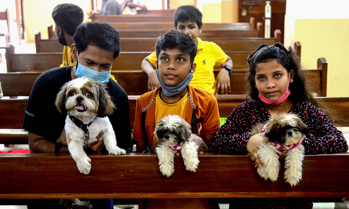 People wait with their pets for them to be blessed by a priest during an animal blessing ceremony at the St. John the Evangelist Church in Mumbai, India on Sunday. Photo: AFP