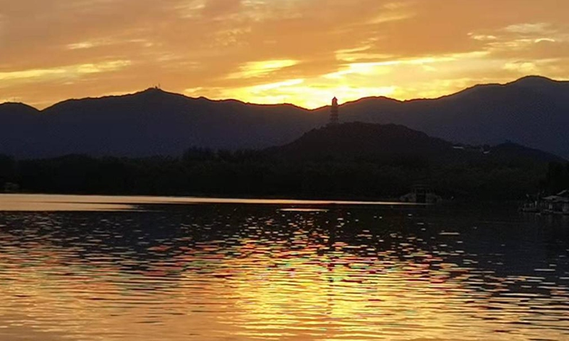 Cellphone photo taken on Oct. 10, 2021 shows the view of sunset glow at the Summer Palace in Beijing, capital of China. (Xinhua/Chen Jianli)
