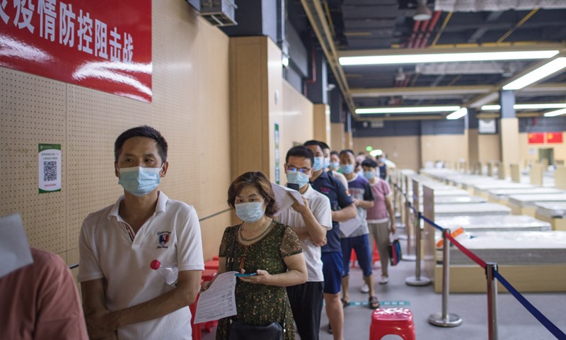 People wearing face masks line up to receive the COVID-19 vaccines at a vaccination site in Jiangxia District in Wuhan, central China's Hubei Province, June 9, 2021. (Photo:Xinhua)