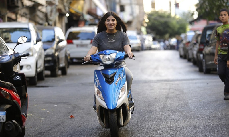 A woman drives a motorbike in Beirut, Lebanon, on Oct. 6, 2021.(Photo: Xinhua)