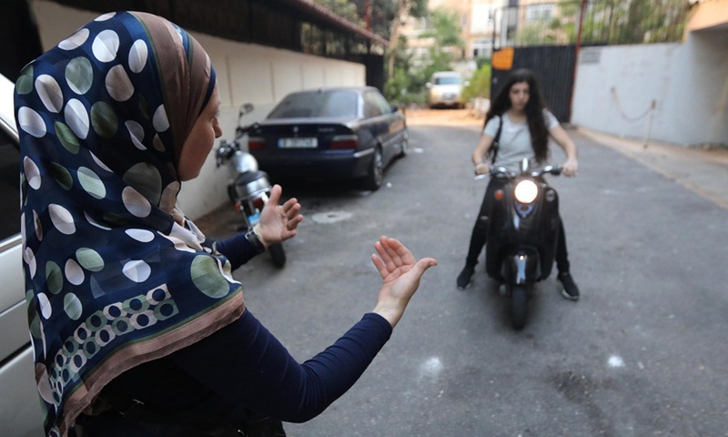 A trainer teaches a woman to drive a motorcycle in Beirut, Lebanon, on Oct. 6, 2021.(Photo: Xinhua)