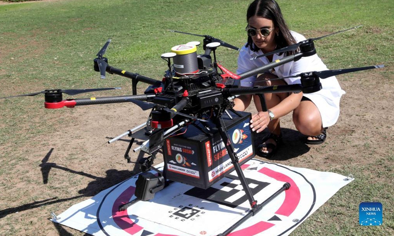 A woman takes out goods delivered by a drone during a presentation to the media in the coastal Israeli city of Tel Aviv on Oct. 11, 2021. (Photo by Gil Cohen Magen/Xinhua)