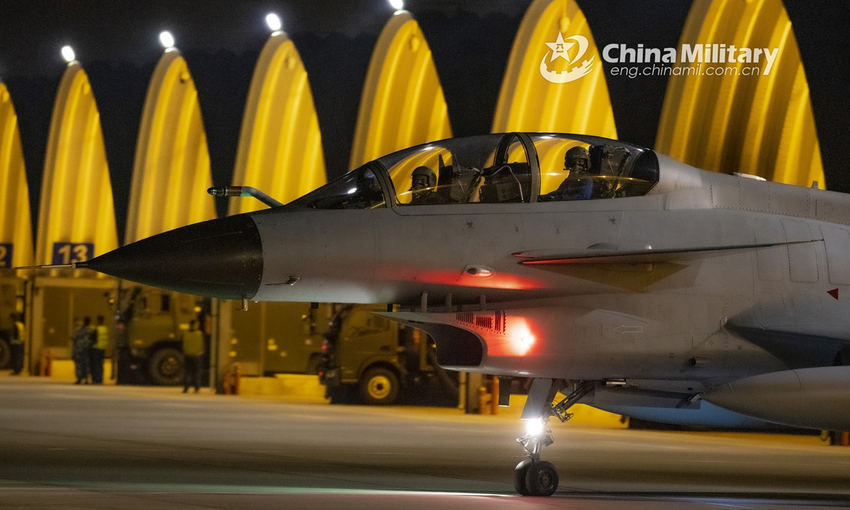 Pilots assigned to an aviation brigade of the air force under the PLA Southern Theater Command perform pre-flight procedures inside the cockpit and taxi their fighter jet out of hangar during a midnight flight training exercise on September 26, 2021. (eng.chinamil.com.cn/Photo by Wang Guoyun)