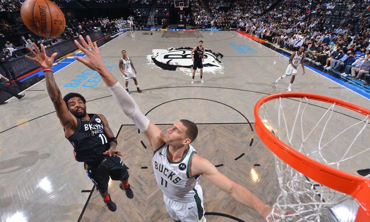 Kyrie Irving (left) of the Brooklyn Nets shoots the ball against the Milwaukee Bucks on June 7 in New York City. Photo: VCG