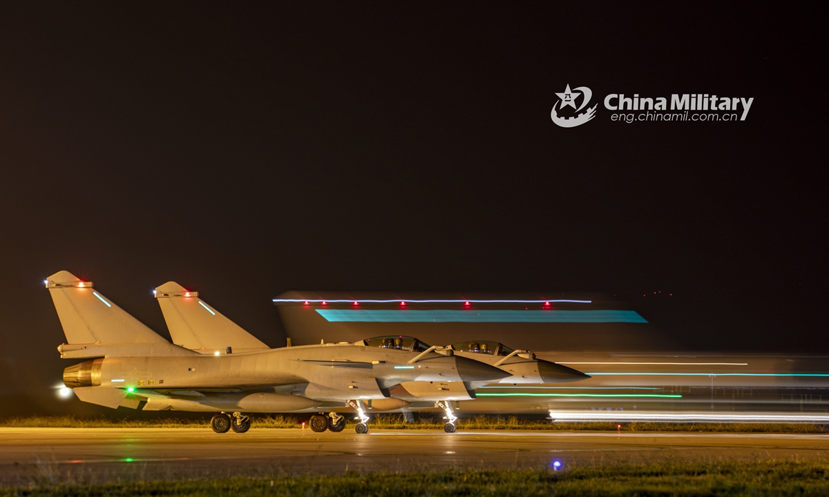 Two fighter jets attached to an aviation brigade of the air force under the PLA Southern Theater Command get in position to take off during a midnight flight training exercise on September 26, 2021. (eng.chinamil.com.cn/Photo by Wang Guoyun)
