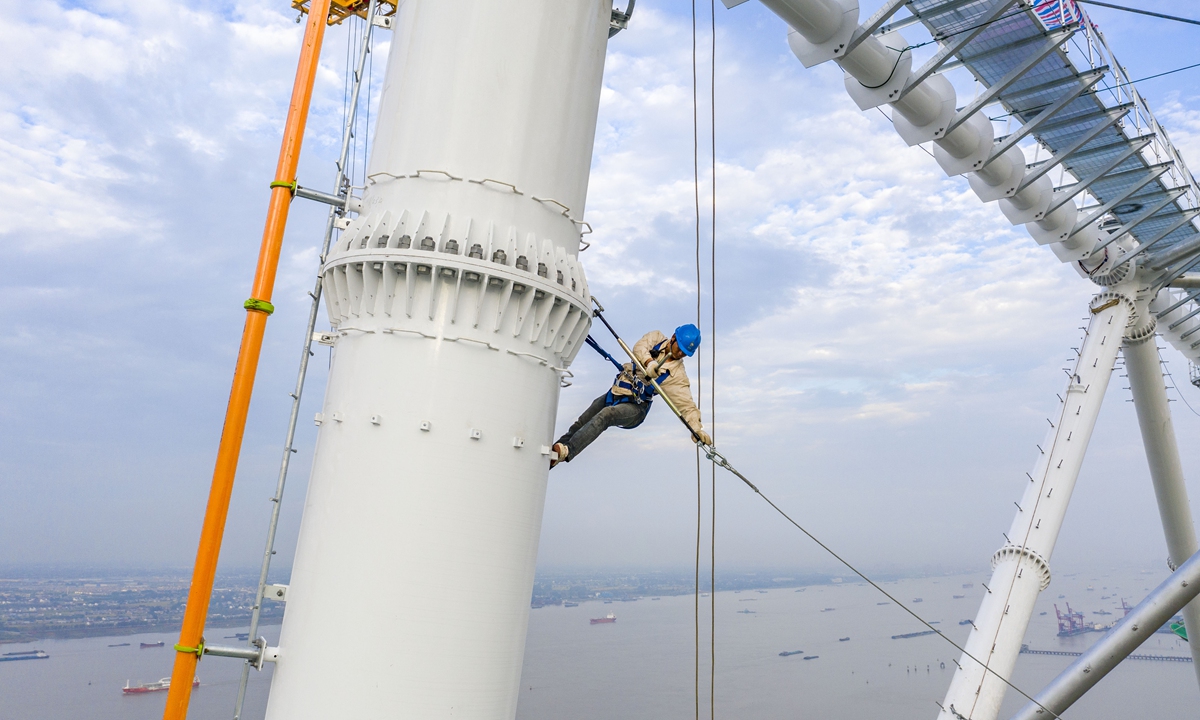 A worker builds a transmission tower at a height of 385 meters on Thursday in East China's Jiangsu Province in order to complete the project on time. The 500-kilovolt tower will move electricity across the Yangtze River between Fengcheng and Meili in Jiangsu. Photo: cnsphoto