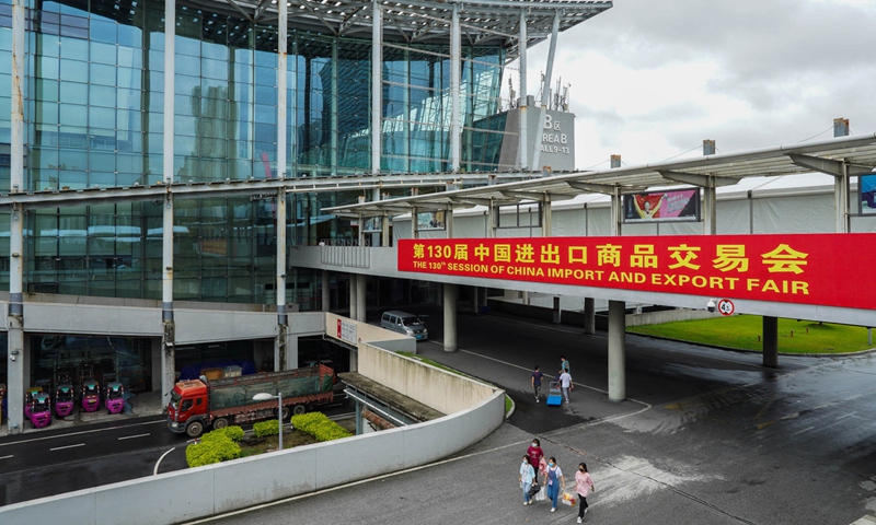 Staff members walk past a banner outside the exhibition center that is going to host the 130th session of the China Import and Export Fair in Guangzhou, South China's Guangdong province.Photo: Xinhua