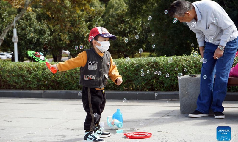 A kid plays with a bubble machine near the Dianchi Lake in Kunming, southwest China's Yunnan Province, Oct. 13, 2021.Photo:Xinhua