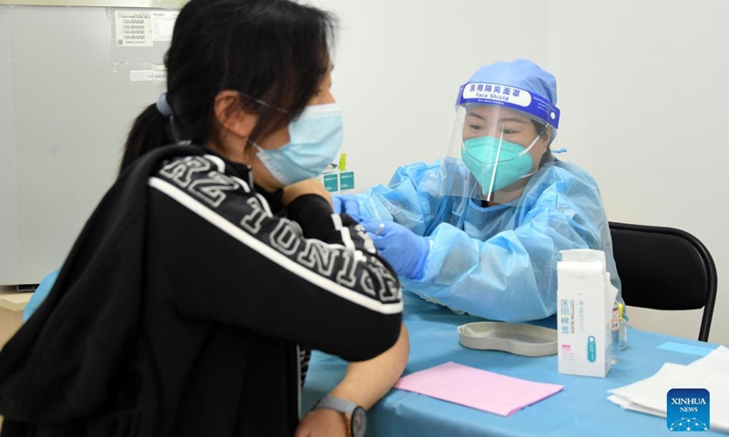 A medical worker administers a booster shot of the COVID-19 vaccine to a woman at a vaccination site in Xicheng District of Beijing, capital of China, Oct. 17, 2021. Beijing has begun to offer a third COVID-19 booster vaccine to people of higher risks in some neighborhoods.