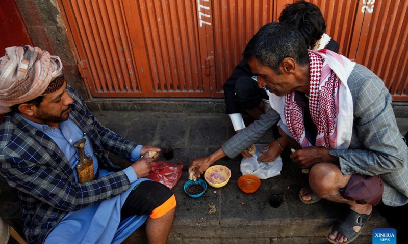 Yemeni men eat pitta bread with beans on a street in Sanaa, Yemen, on Oct. 16, 2021, World Food Day.Photo: Xinhua 
