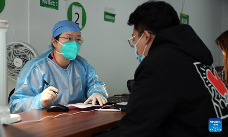 A medical worker asks a man about his physical condition at a vaccination site in Xicheng District of Beijing, capital of China, Oct. 17, 2021. Beijing has begun to offer a third COVID-19 booster vaccine to people of higher risks in some neighborhoods.Photo: Xinhua