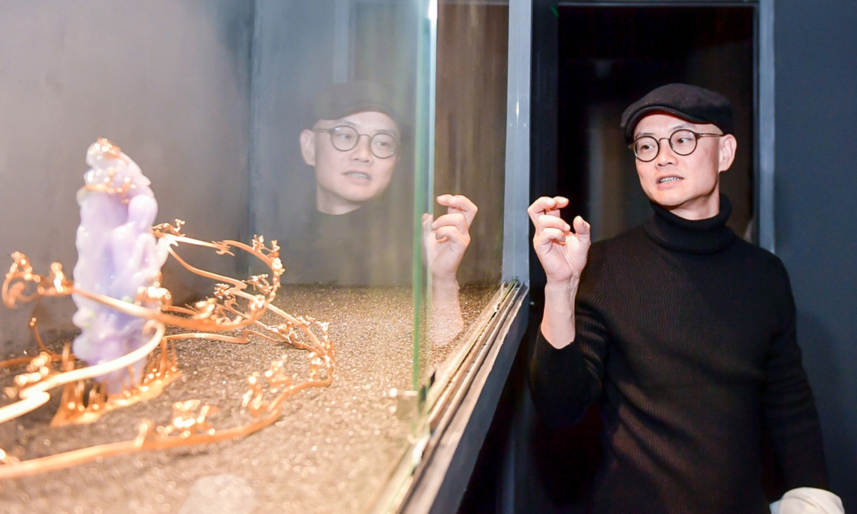 Artist Qiu Qijing and his artwork at the exhibition Photo: Courtesy of zhang guisen