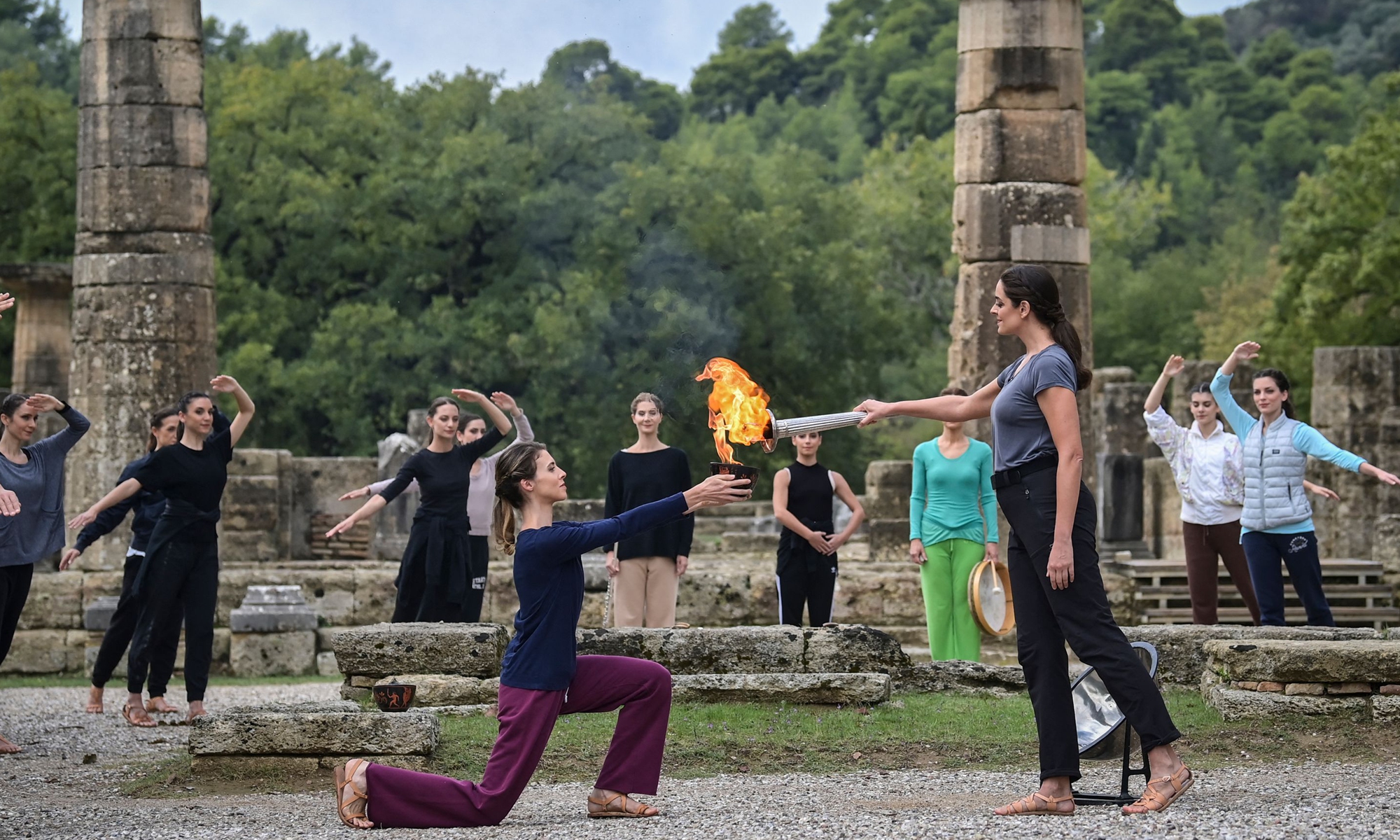 Greek actress Xanthi Georgiou (right), playing the role of the High Priestess, lights the Olympic torch on Sunday during the last rehearsal of the flame lighting ceremony for the Beijing 2022 Winter Olympics at the Ancient Olympia archeological site, birthplace of the ancient Olympics in southern Greece. Photo: VCG