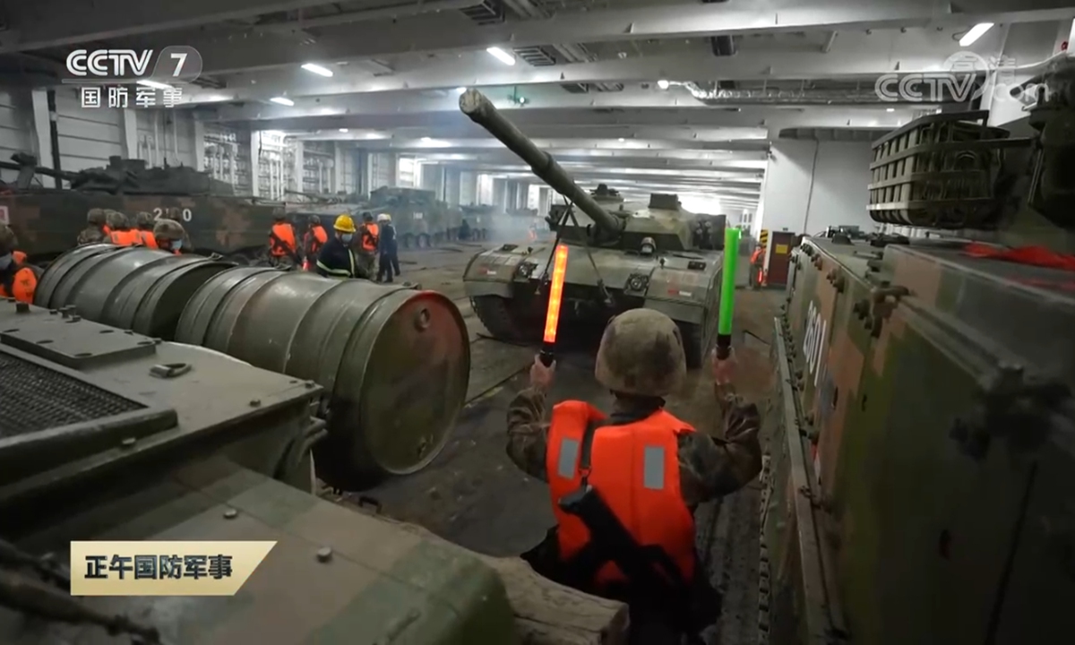 A combined arms brigade affiliated with the PLA 81st Group Army uses the <em>Chinese Rejuvenation</em> ferry to transport troops and vehicles, including Type 96 main battle tanks, in a military-civilian integrated, cross-sea troop maneuvering exercise in October 2021. Photo: Screenshot from CCTV