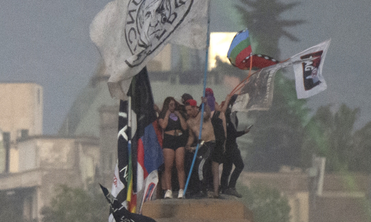 People demonstrate during a protest to mark the second anniversary of months of civil uprising against social inequality in Santiago, Chile on Monday. Photo: AFP