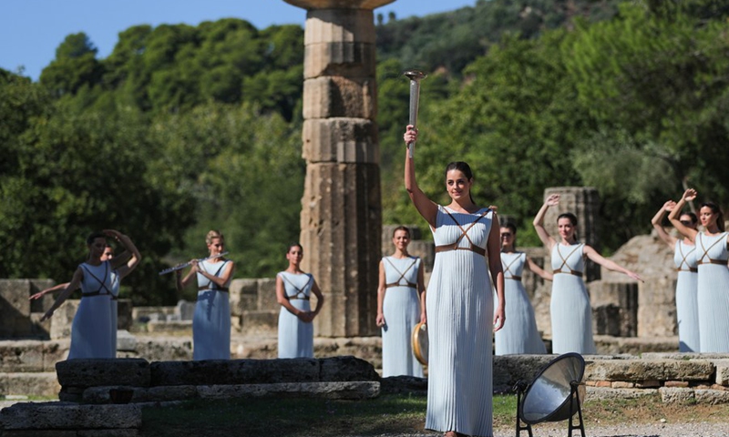 Greek actress Xanthi Georgiou, playing the role of an ancient Greek High Priestess, presents the torch during the Olympic flame lighting ceremony for the Beijing 2022 Olympic Winter Games, in ancient Olympia, Greece, Oct. 18, 2021. (Photo: Xinhua)