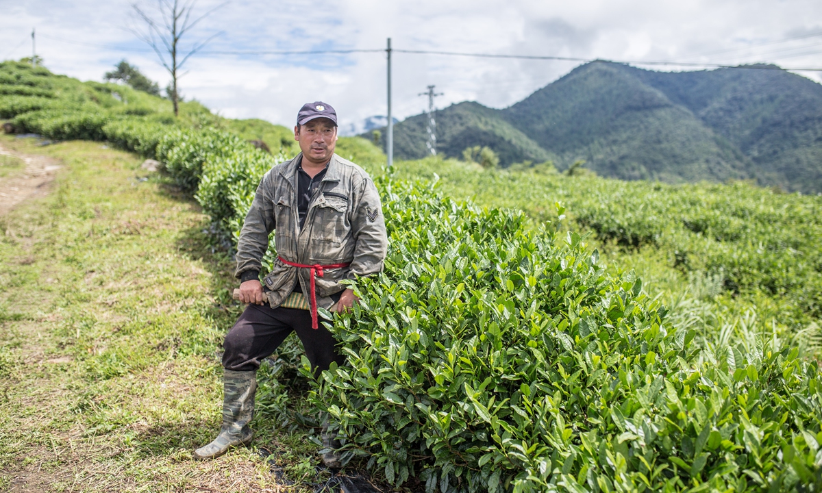 Sangye Dawa, a Gelin villager and a veteran in border patrol, holds his Monba knife and poses in the village's the tea garden. Photo: Shan Jie/GT
