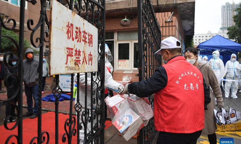 A volunteer delivers daily necessities to a closed-off community in Chengguan District of Lanzhou City, northwest China's Gansu Province, Oct. 19, 2021..Photo: Xinhua
