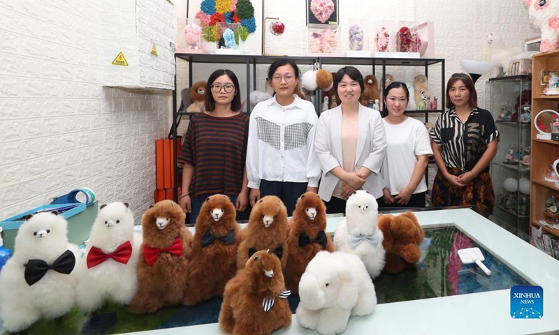 Ma Yuxia (C) and her employees pose for group photos in her office at the Peru Import Pavillon of the Greenland Global Commodity Trading Hub in Shanghai, east China, Oct. 15, 2021. Photo: Xinhua