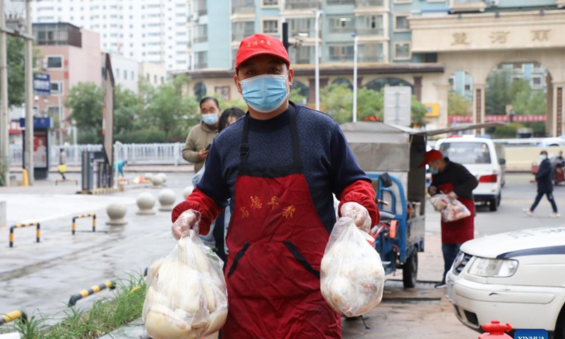 A restaurant staff delivers breakfast to residents at a closed-off community in Chengguan District of Lanzhou City, northwest China's Gansu Province, Oct. 19, 2021.Photo: Xinhua