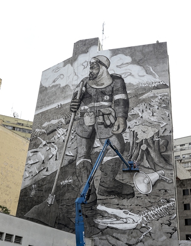 Mural painted by artist and activist Mundano on a building in the central region of Sao Paulo, Brazil, on Friday. 
Top: Brazilian artist Mundano shows ashes collected from wildfires to media.
Photos: AFP