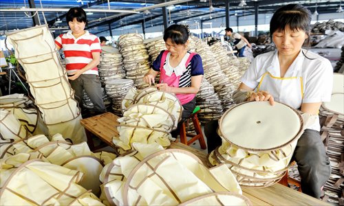 Workers pack a foldable pet product for export in Wuyuan, East China's Jiangxi Province on Saturday. The producer, a private company in Wuyuan focusing on environmental protection and foldable housewares, has an annual output worth 200 million yuan ($32.5 million), and offers 1,500 jobs for local farmers. Photo: CFP