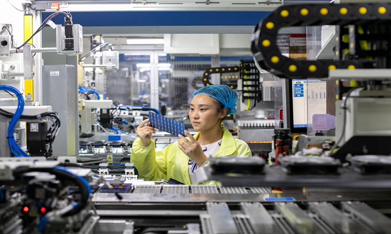 A worker makes photovoltaic solar modules for export at a 5G plus smart workshop in Nantong, East China's Jiangsu Province on October 20, 2021. The workshop was built by the new-energy unit of Jiangsu Focus Group in 2020 to realize equipment and data interconnection through 5G technology, which improves production and efficiency. Photo: VCG
