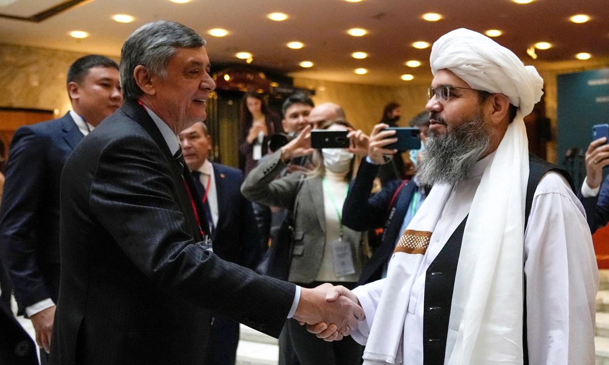 Russian presidential envoy to Afghanistan Zamir Kabulov (L) shakes hands with a member of the Taliban delegation Mawlawi Shahabuddin Dilawar prior to an international conference on Afghanistan in Moscow on October 20, 2021. Photo:AFP