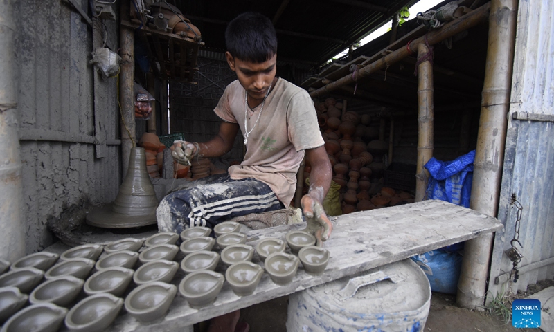 A potter arranges earthen lamps made for Diwali, the Hindu Festival of Lights, in Nagaon district of India's northeastern state of Assam, Oct. 21, 2021. Photo: CFP