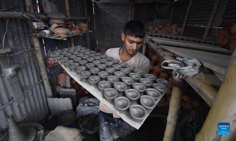 A potter arranges earthen lamps made for Diwali, the Hindu Festival of Lights, in Nagaon district of India's northeastern state of Assam, Oct. 21, 2021. Photo: CFP
