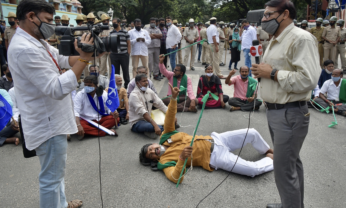 Media personnel watch as various farmers stage a protest demonstration in Bangalore on September 25, 2020. Photo: AFP